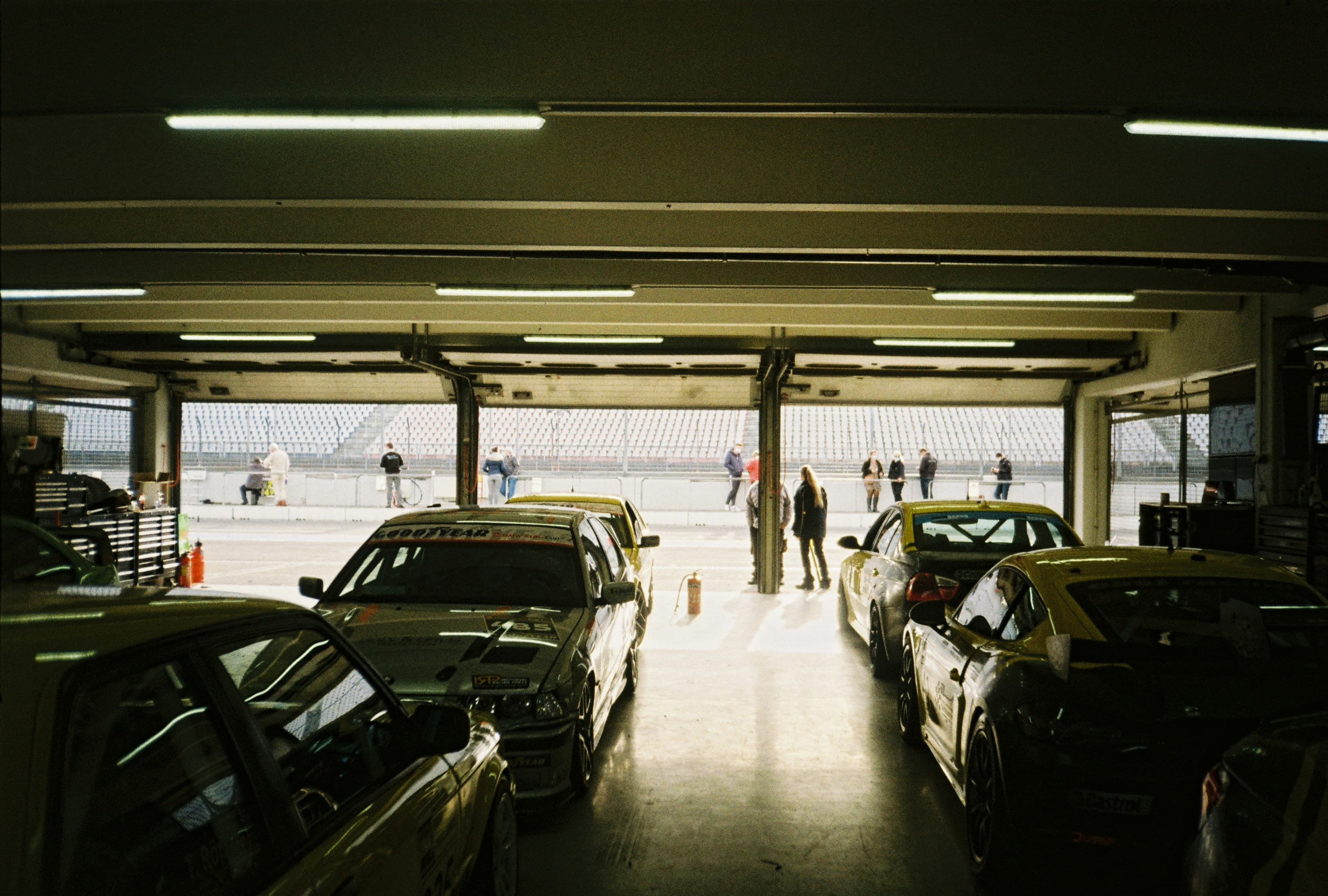 enthusiast race cars in a paddock garage